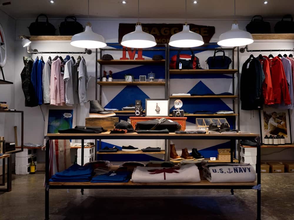 Interior de una tienda de ropa con percheros y estanterías de producto